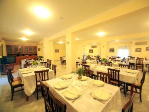 uma sala de jantar com mesas e cadeiras com toalhas de mesa brancas em Hotel Viteama em Sellia Marina