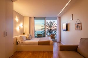 Schlafzimmer mit einem Bett und Meerblick in der Unterkunft Meraki Beach Hotel - Only Adults in Playa Pobla de Farnals