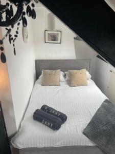 una cama blanca con un cartel que dice que es lácteo en Cosy Seaside Cottage en Allonby