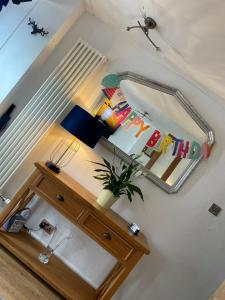 a mirror and a table with a plant on it at Cosy Seaside Cottage in Allonby