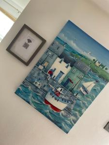 a picture of a boat in the water on a wall at Cosy Seaside Cottage in Allonby