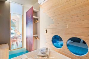 een kamer met een houten muur met twee ronde spiegels bij Riflessi di Mare, TerreMarine in Portovenere