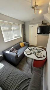 ein Wohnzimmer mit einem Sofa und einem Tisch in der Unterkunft 4 Bedroom 4 En Suite House Close to A5 & Whipsnade in Luton