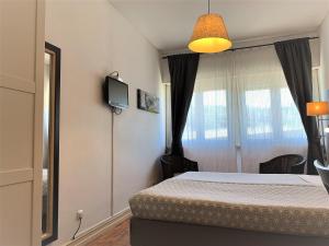 a bedroom with a bed and a tv on the wall at Discovery Apartment Benfica in Lisbon