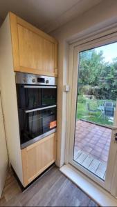 a kitchen with an oven and a sliding glass door at 4 Bedroom 4 En Suite House Close to A5 & Whipsnade in Luton