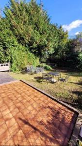 a patio with a table and a picnic table at 4 Bedroom 4 En Suite House Close to A5 & Whipsnade in Luton