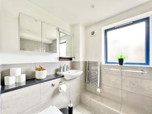 een badkamer met een wastafel en een spiegel bij WEEKLY OR MONTHLY STAY - Relocation & Business - 4 Guests - By Hofin Stays Short Lets & Serviced Accommodation in Londen