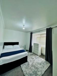 een slaapkamer met een groot bed en een raam bij Blue rain in Hillingdon