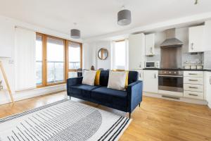 a living room with a blue couch in a kitchen at The Highbury Collection in London