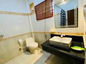 a bathroom with a toilet and a sink at Fiesta Inn Hotel & Resorts Multan in Multan +80 photos