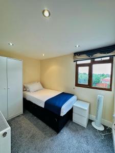 a small bedroom with a bed and a window at Blue rain in Hillingdon
