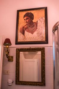 a framed painting of a woman on a bathroom wall at Flora in Rome