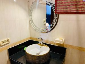 a bathroom with a sink and a mirror at Fiesta Inn Hotel & Resorts Multan in Multan