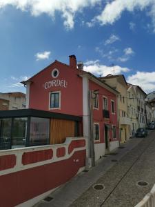 un edificio rosso sul lato di una strada di Casa do Convento AL/141600 a Coimbra