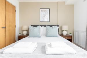 a bedroom with a large white bed with two lamps at The Highbury Collection in London