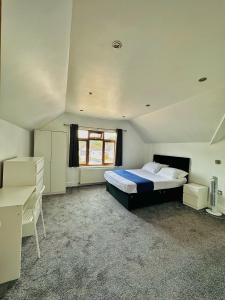 ein großes Schlafzimmer mit einem Bett und einem Fenster in der Unterkunft Blue rain in Hillingdon