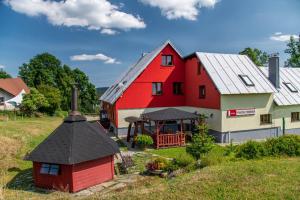 um celeiro vermelho e branco com um gazebo em Penzion Podkůvka em Kořenov