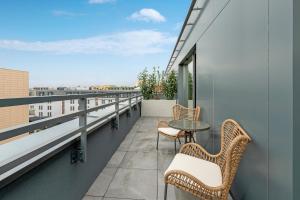 a balcony with two chairs and a table on a building at Flatbook - City Center Apartments Scala Moderna in Gdańsk