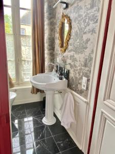 a bathroom with a sink and a mirror on the wall at L'Hotel de Hercé Chambre d'Hote in Mayenne