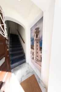 a hallway with stairs and a picture of a clock tower at Casa do Convento AL/141600 in Coimbra