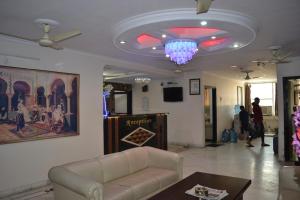 a living room with a couch and a chandelier at Hotel Jigyasa By Mayda Hospitality Pvt. Ltd. in Agra