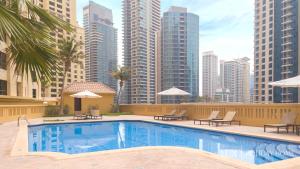 a swimming pool with a city skyline in the background at LUX The Luxurious Central JBR Suite in Dubai