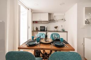een keuken met een houten tafel met blauwe stoelen bij ApartHouse Porto in Piran