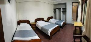 a hospital room with three beds and a table at RESIDENCIAL CAÑADA in Santa Cruz de la Sierra