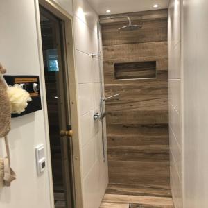 a bathroom with a wooden door in a room at Private space with 2 bedrooms in Huddinge