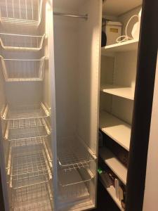 um frigorífico vazio com a sua porta aberta com as suas prateleiras em Private space with 2 bedrooms em Huddinge