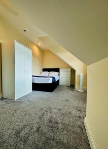 an empty room with a bed and a closet at Blue rain in Hillingdon