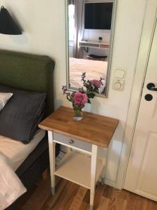 a table with a vase of flowers on it in a bedroom at Private space with 2 bedrooms in Huddinge