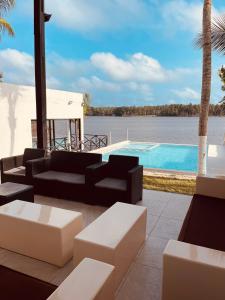 a patio with couches and a swimming pool at Villa Assinie Bord de Lagune in Assinie