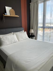 una camera da letto con un grande letto bianco e una finestra di NL Core Soho Suite KLIA Sepang a Sepang