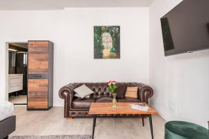 a living room with a brown couch and a table at Logement viphouse Valkenburg in Valkenburg