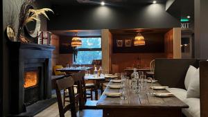 uma sala de jantar com uma mesa e uma lareira em Fiddle + Bow Hotel em Doolin