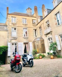 two motorcycles parked in front of a building at L'Hotel de Hercé Chambre d'Hote in Mayenne