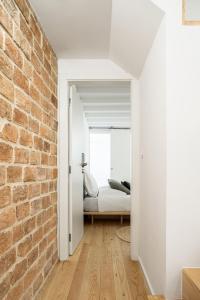 a bedroom with a bed and a brick wall at Loureiro 59 in Coimbra