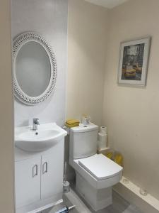 a bathroom with a white toilet and a sink at Serenity Station in Hornsea