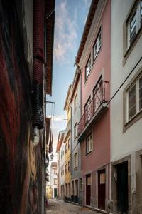un callejón en una ciudad con edificios altos en Loureiro 59, en Coímbra