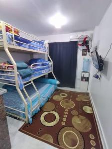 Habitación con literas y alfombra en el suelo en not for rent now, en Raʼs Matarma