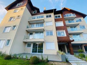 an apartment building with a gambrel roof at Apartamento Novo Aconchegante e Moderno em Canela in Canela