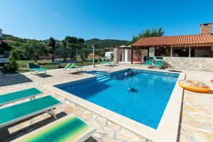 a swimming pool with chairs and a house at House Neverra 2 in Banj