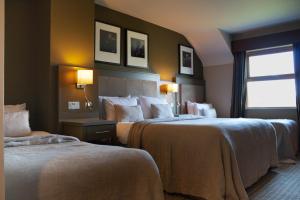 een hotelkamer met 2 bedden en een raam bij Fiddle + Bow Hotel in Doolin