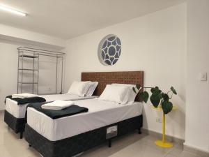 a bedroom with two beds and a clock on the wall at Vila Madalena, casa 4 quartos conforto e segurança in São Paulo