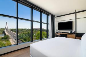 a bedroom with a large bed and large windows at Barceló Warsaw Powiśle in Warsaw +36 photos