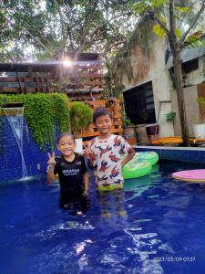 Zwei junge Jungs stehen im Pool in der Unterkunft Tasek Homestay D Village Ipoh in Ipoh