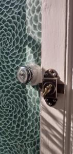 a bathroom door with a door knob on a wall at Maison blanche in Cherval