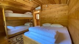 a room with two bunk beds in a wooden cabin at Kaçkar Kavrun Dağ Evleri in Rize