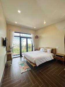 a bedroom with a large bed and a large window at Hue Sweethouse 2 Homestay in Hue